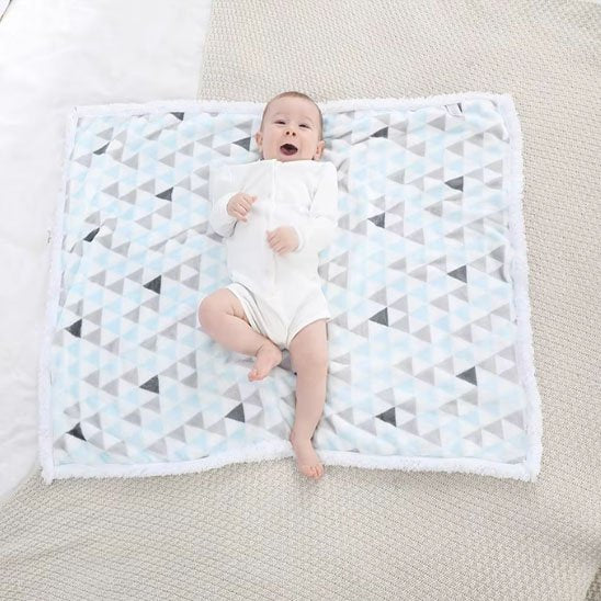 Couverture bébé sur sa couverture qui sourit a papa
