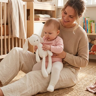 Doudou lapin bébé assis sur maman qui caresse son  doudou lapin blanc